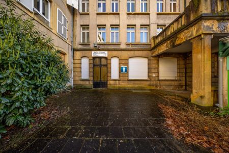 Vue depuis le centre de la cour sur l'entrée D du bâtiment du fond.